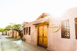 a building with a wooden door on a street at Hostal Tulvak Atacama in San Pedro de Atacama
