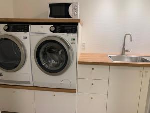 a kitchen with a washing machine and a sink at Spacious Apartment on N.P.Gøta 8a, Klaksvik in Klaksvík