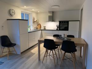 Spacious Apartment on N.P.Gøta 8a, Klaksvik في كلاكسفيك: مطبخ مع طاولة وكراسي في غرفة