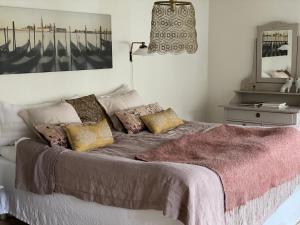ein Schlafzimmer mit einem großen Bett mit Kissen darauf in der Unterkunft Elins Lycka i Viken in Viken