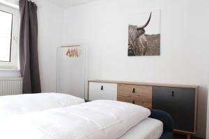 a bedroom with two beds and a picture of a bull on the wall at EG Apartment - WLAN - Terrasse - Parkplatz in Buchenberg