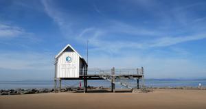 a life guard shack on a beach with the ocean at Eden Vale Ground Floor Sea View Apartment in Morecambe