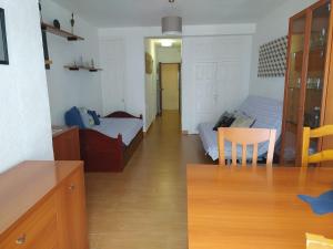 1 dormitorio y sala de estar con mesa de comedor. en Apartamento estudio Acantilados, en Salou