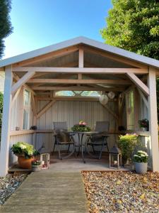 uma pérgola de madeira com uma mesa num deque em Das kleine Stadtapartment em Burg auf Fehmarn