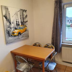 uma sala de jantar com uma mesa e um carro amarelo na parede em NiceRooms Aachen em Würselen
