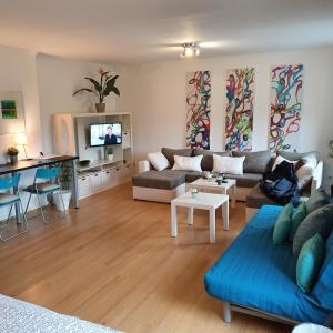 a living room with a couch and a tv at NiceRooms Aachen in Würselen