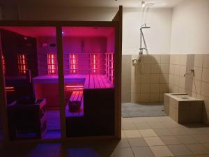 a bathroom with purple lights in a room at Apartment Feher Lendava in Lendava