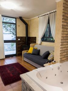 uma sala de estar com um sofá e uma banheira em Adva High Above All em Rosh Pinna