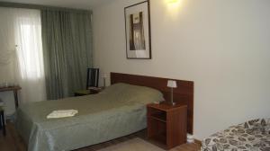 1 dormitorio con 1 cama y 1 mesa con lámpara en Guest House Comfort, en Ufa