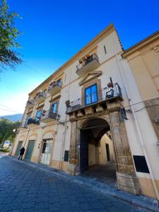 um homem parado em frente a um edifício em Cortile Umberto I em Cefalù