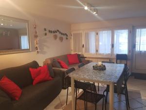 un salon avec un canapé et une table dans l'établissement Apartment Le Logge, à Sestrières