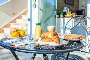 einen Tisch mit einem Frühstück mit Croissants, Brot und Orangensaft in der Unterkunft Acquazzurra guest house in Tortolì