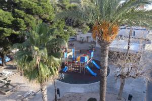 an overhead view of a playground in a resort with palm trees at APARTAMENTOS AGUAMARINA in Peñíscola
