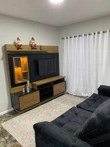 a living room with a couch and a flat screen tv at Apartamento praia BC Central novo in Balneário Camboriú