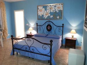 1 dormitorio azul con 1 cama y 2 lámparas en B&B Pittoresco, en Specchia