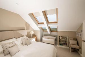 a bedroom with a white bed and some windows at Luxurious home overlooking Cruden Bay golf course in Cruden Bay