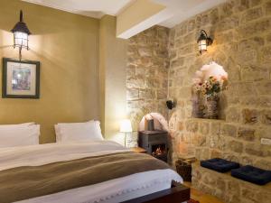 um quarto com uma cama e uma parede de pedra em Adva High Above All em Rosh Pinna