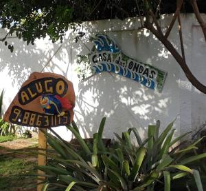 a sign in front of a white building with a sign at Casa das Ondas Guarajuba in Guarajuba