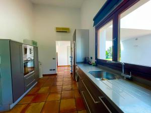 a large kitchen with a sink and a window at Casa Pepa con Encanto in Ondara