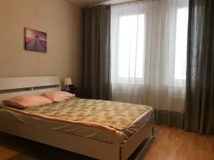 a bedroom with a bed and a large window at Apartment Maria in Zelenograd