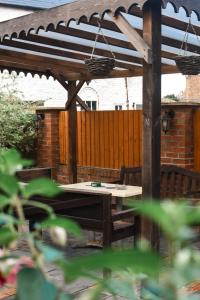 a wooden pergola with a picnic table in a backyard at The Crown and Woolpack in Long Sutton