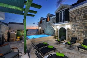eine Terrasse mit Pool und ein Haus in der Unterkunft Luxury Villa Topolina in Baška Voda