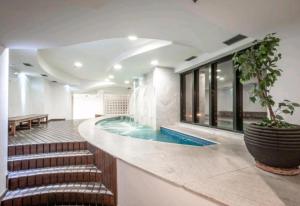 a swimming pool in a building with a stairway leading to a swimming pool at Guarulhos flat services, aeroporto in Guarulhos