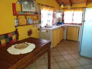 San Isidro的住宿－Catamarca Hospedaje Star，一间带木桌的厨房和一间带黄色墙壁的厨房