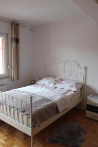 1 dormitorio con 1 cama con marco blanco en Studio apartman Ivano, en Ðakovo