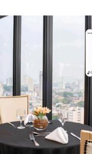 瓜魯柳斯的住宿－Guarulhos flat services, aeroporto，一张桌子,上面有黑色桌布,一张桌子,上面有眼镜