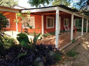 ein kleines orangefarbenes Haus mit einer Veranda in der Unterkunft Catamarca Hospedaje Star in San Isidro
