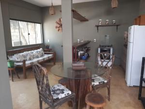 a living room with a table and chairs and a refrigerator at Casa hibiscus in Itacaré