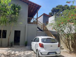a white car parked in front of a house at Casa hibiscus in Itacaré