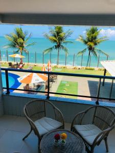 a balcony with a table and chairs and a view of the beach at Apartamento em Tabatinga in Conde