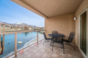 a balcony with a table and chairs and a view of the water at Grandview Lake Chelan- Waterfront View, Pool, Hot tub, Golf, 1 Min To Downtown in Chelan