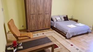 a bedroom with a bed and a chair and a table at APARTAMENT PLAC KATEDRALNY in Tarnów