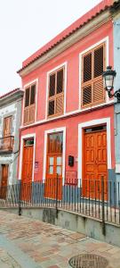 a red building with wooden doors and a fence at Casa Rural Encarna in Vega de San Mateo