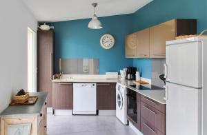 a kitchen with blue walls and a white refrigerator at Maison de 3 chambres a Erbalunga a 10 m de la plage avec vue sur la mer jardin clos et wifi in Erbalunga