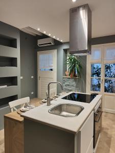 uma cozinha com um lavatório e um balcão em medium miramare appartamento sogno sul mare em Trieste