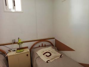 Dormitorio pequeño con cama y mesita de noche con lámpara en Mare Verde - JOY, en Adeje