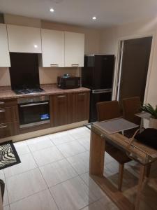 a large kitchen with a table and a microwave at Immaculate 3 bedroom property. in Nottingham