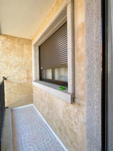uma janela com uma cortina na parede em CÓMODO alojamiento en Alba de Tormes em Alba de Tormes