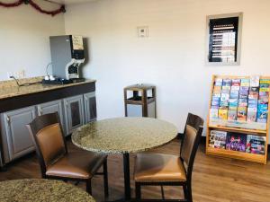 a room with a table and chairs and a counter at Motel 6 Tulsa, OK Airport in Tulsa