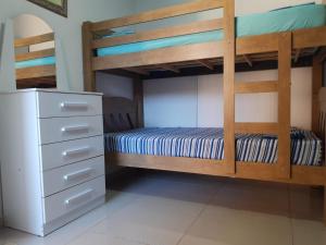 a bedroom with two bunk beds and a dresser at Suíte Santin: o seu conforto está aqui! in Foz do Iguaçu