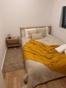 a bedroom with a large bed with a yellow blanket at CASA DO PENEDO - Um Segredo na Serra da Estrela in Quintãs de Baixo
