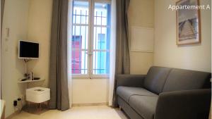 a living room with a couch and a window at Holiday in Arles: Appartement de l'Amphithéâtre in Arles