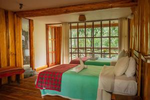 2 camas en una habitación con ventana en Eco Quechua Lodge en Santa Teresa