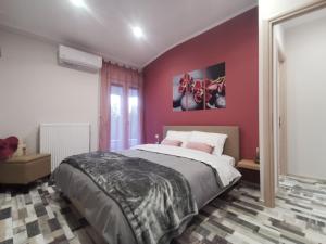 una camera con un grande letto e una parete rosa di V&L Sunset a Ioannina