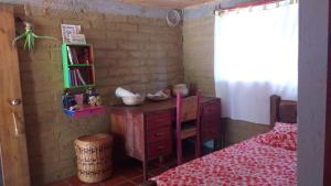 Schlafzimmer mit einem Schreibtisch und einem Bett in einem Zimmer in der Unterkunft Granja Los Conejos in Ramiriquí