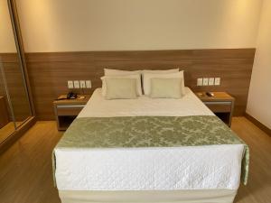 sypialnia z dużym łóżkiem z dwoma stołami w obiekcie SUÍTE NO VISTA AZUL APART w mieście Pedra Azul